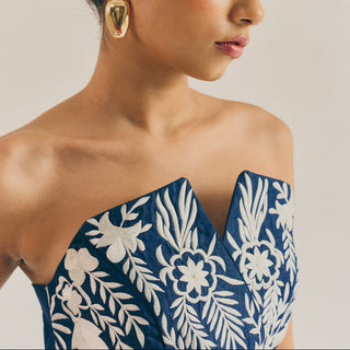 Woman wearing a blue floral dress with a neutral background